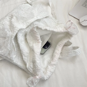 Internal view of white lace drawstring bag showing spacious capacity with a smartphone