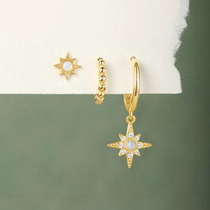 Detail of gold star earrings set featuring white opal stones and micro-pave zircons