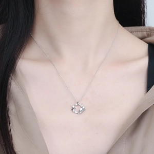 Detailed view of silver planet and star pendant necklace inlaid with zircon on neck