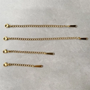 Golden stainless steel extender chains with lobster clasps in four lengths on grey surface