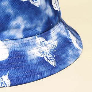 Blue tie-dye bucket hat with white butterfly prints and premium stitching detail