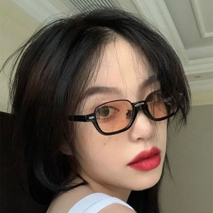 Chic black rectangular semi-rimless sunglasses with light orange lenses on a female model