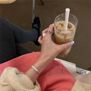Lifestyle shot of 925 sterling silver bow ring and textured bangle set on model