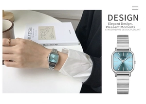 Detail view of a women's square silver watch with a light blue sunray texture dial
