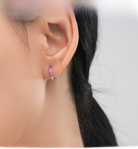 Close-up of S925 sterling silver hoop earring with pink zircon stones worn by a model