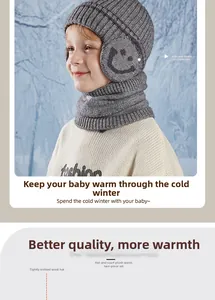 Close-up of children's grey knit hat and scarf set with ear protection and smiley face