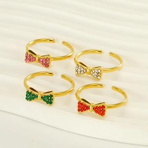 Detail view of adjustable bow rings with colorful rhinestones in gold finish