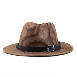 Brown straw Panama hat with a black leather band and silver buckle on white background