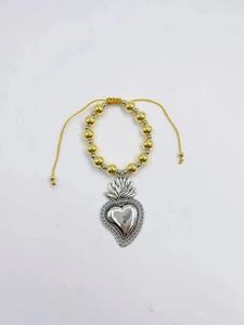 Détail d'un pendentif cœur sacré gothique sur un bracelet ajustable en perles dorées