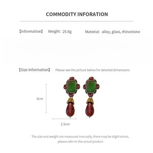 Detailed product specs of vintage drop earrings with red rhinestones and green relief