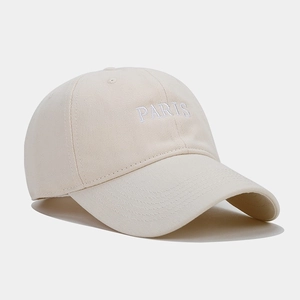 Detail of white PARIS embroidery on light beige cotton twill baseball cap