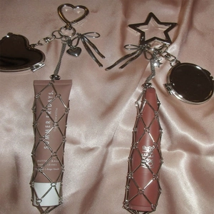 Close-up of silver metal mesh lipstick holder keychain with heart-shaped mirror and clasp