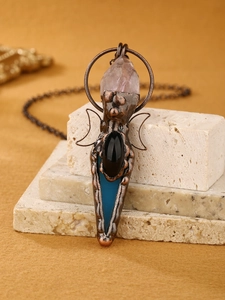 Detalle del collar de bronce vintage con cristal de amatista y colgante de flecha de ágata