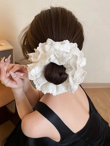 Detailed view of white double-layer lace scrunchie styled on a classic hair bun
