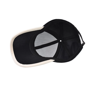 Detailed interior view of a black baseball cap featuring reinforced seams and ivory brim edge