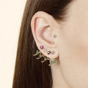 Elegant 14K gold flower stud earrings set with colorful diamonds on female ear model