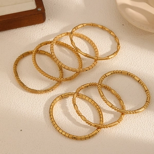 Stack of vintage bamboo textured gold stainless steel bangles for women in natural light