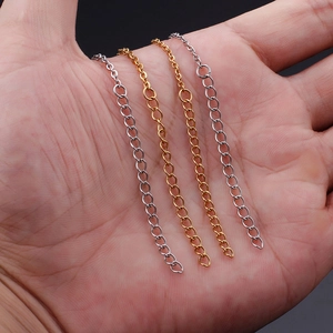 Close-up of gold and silver stainless steel extension chains shown on palm