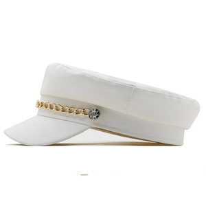 Detail of white leather military cap with golden metal chain and embossed silver buttons