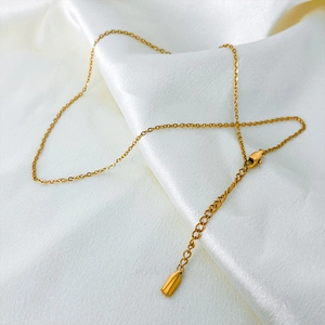 Detailed macro view of a 14K gold plated necklace chain with lobster clasp on white silk