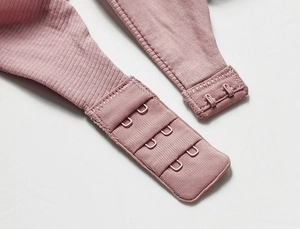 Detail of three-row hook-and-eye closure and ribbed fabric on dusty rose wireless bra
