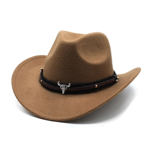 Detail of western cowboy hat with metal bull skull emblem and silver rivets on band
