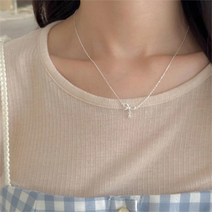Elegant 925 sterling silver bow pendant necklace with zircons worn by a model