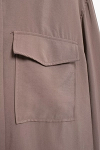 Nahaufnahme einer braunen Morandi-Bluse mit Brustpattentasche und Stoffstruktur