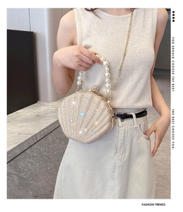 Detail of shell-shaped evening bag with pearl handle and sparkling rhinestone texture