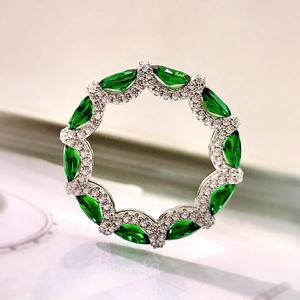 Detailed close-up of 925 silver ring set with emerald-cut green gems and diamonds