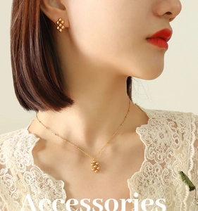 Close-up of gold geometric bead jewelry set worn by a model in white lace