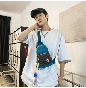 Detail of teal crossbody bag with orange trim and checkered pocket on a male model