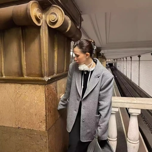 Vintage grey wool blazer coat for women worn in a classic subway station setting