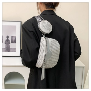 Detail of silver studded crossbody bag with fringe tassel and patterned webbing strap