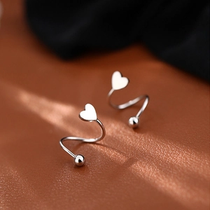 Elegant silver heart-shaped spiral stud earrings with high-gloss finish on leather surface