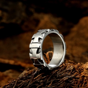 Vintage silver floral cross ring with rustic texture displayed on natural wood background