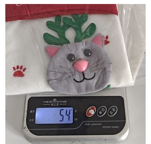 Vista dettagliata di una calza di Natale a forma di gatto grigio pesata su bilancia da 54g