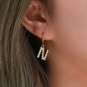 Close-up of gold 18K plated earring featuring a letter N pendant with micro-pave zircons