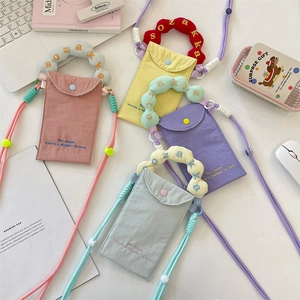Close-up of colorful mini phone bags in pastel tones with embroidered ruffle handles