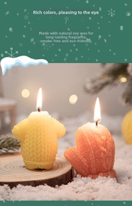Detail of sweater and glove shaped candles on wood with faux snow for cozy decor