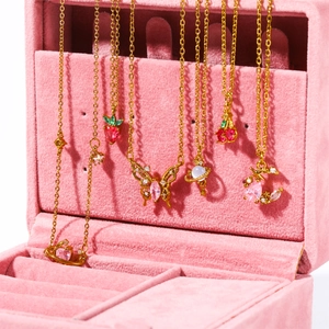 Chic gold-plated necklace set featuring cherry, butterfly, and planet charms on velvet