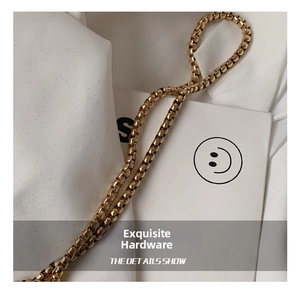 Close-up of a polished gold box chain showing high-gloss metallic finish and texture