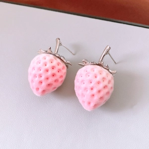 Macro detail showing texture of pink flocked strawberry stud earrings with silver stem