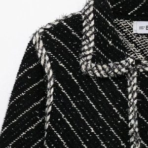 Elegant black and white tweed jacket suit featuring fringe detail and luxury textured fabric