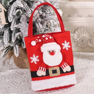 Detail of red knitted Santa gift bag with plush trim and snowflake patterns