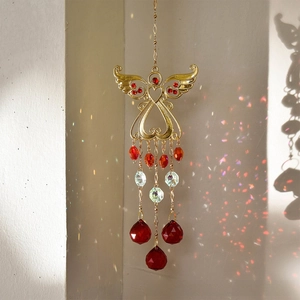 Detail of angel wing suncatcher with red heart crystals and vibrant rainbow prism effects