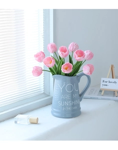 Pink artificial tulips in a blue ceramic pitcher vase with a sweet English quote