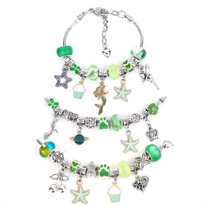 Close-up of DIY ocean-themed charm bracelets with blue beads and silver sea life pendants