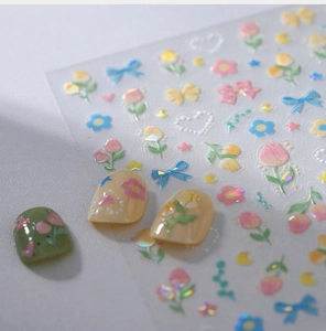 Macro view of holographic tulip and bow nail stickers with iridescent pearl finish