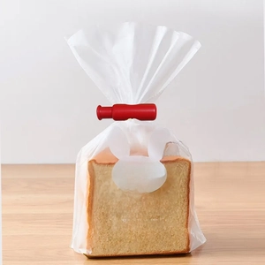 Red plastic sealing clip for food bags, shown securing a clear toast bread package